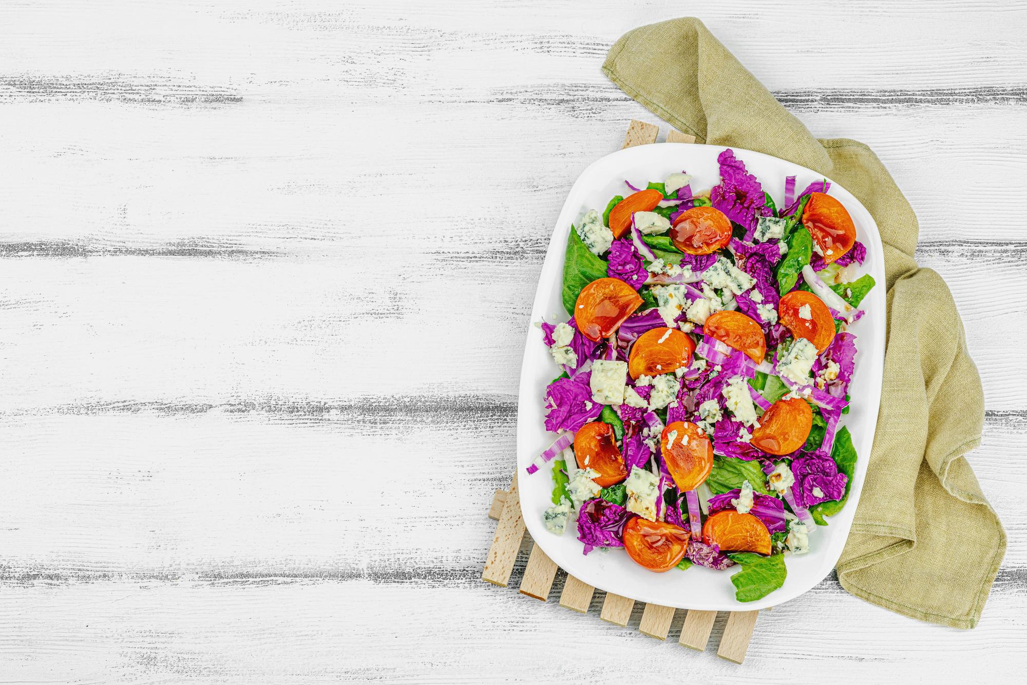 Finished colorful salad on wooden table